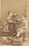 Portrét dvou chlapců s havranem na stole a malým psíkem u nohou. Ateliér H. Eckert &amp; J. Müller’n. Praha. 23.10.1878.